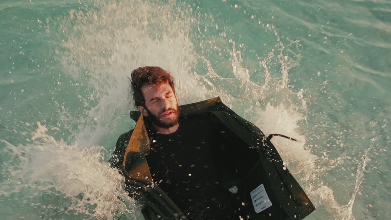 닫힌 눈을 가진 이스라엘 남자가 죽은 바다에 뒤로 떨어지고, 클로즈업 슬로모