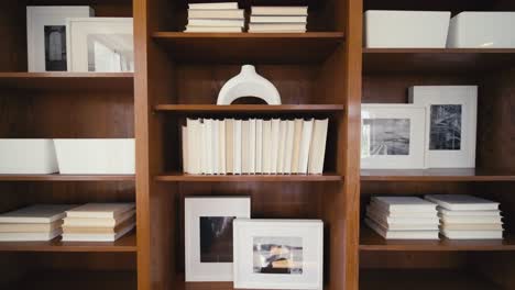 white books and other decorations on a large book shelf in a home office