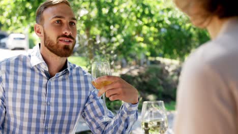 Man-interacting-with-female-friend-while-having-wine