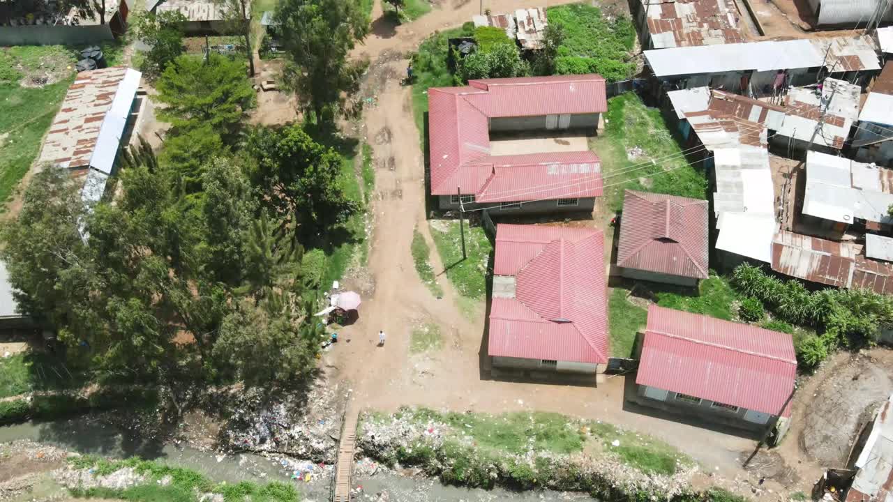drone volando sobre la vieja hoja de techo de las casas en los barrios marginales de kenia, corriente de agua contaminada en los barrios marginales de kibera kenia