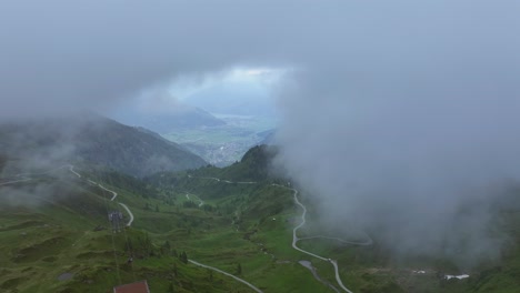 thick fog has descended over the green meadow and ski resort at kitzsteinhorn, austria
