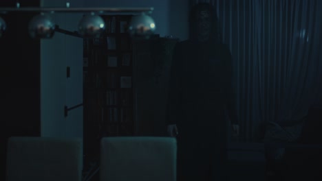 horror scene - a dark and ominous demon walks through a ghastly living room at night