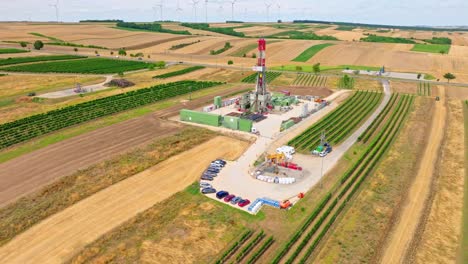 aerial view over equipment for drilling oil and gas well in austria - drone shot