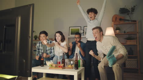 friends celebrating a victory while watching tv