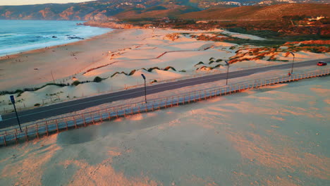 drone shot sandy seaside near green hills at sunset sunlight. seashore road