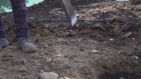 unrecognizable man with shovel digging hole