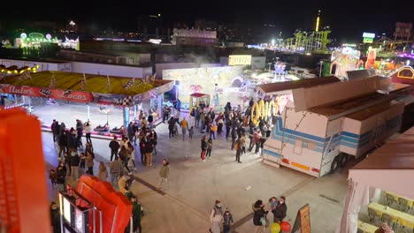 night fair with people enjoying rides and activities