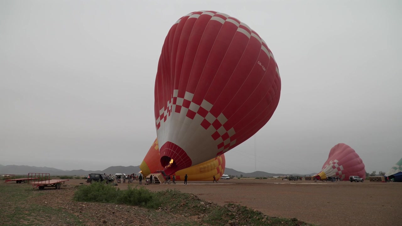 Globo aerostático desinflándose en un día nublado en campo abierto, atmósfera tranquila