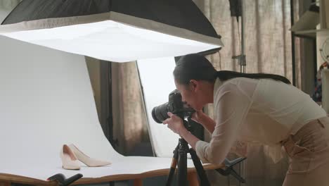 asian female photographer thinking while taking photos of them in home studio