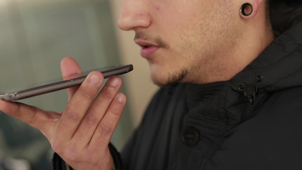 joven con cerdas sosteniendo un teléfono inteligente y hablando