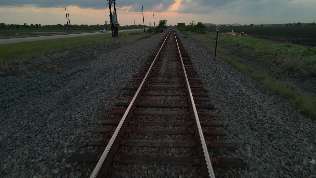 Drone Shot Tracking Very Low Over Railroad Track And Lifting Up High Over Power Lines And Road In Texas, U.S.A.