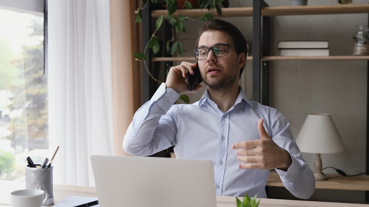 joven empresario feliz con gafas sosteniendo una llamada de teléfono móvil.