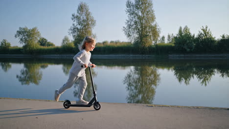 girl riding scooter by the lake