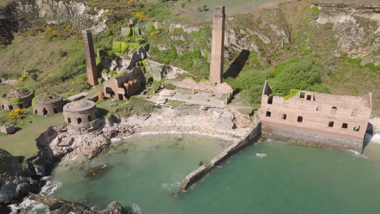Fornace di Porth Wen, Anglesey, Galles. Lenta orbita con allontanamento che rivela la posizione del sito, mostrando edifici abbandonati vicino al mare.