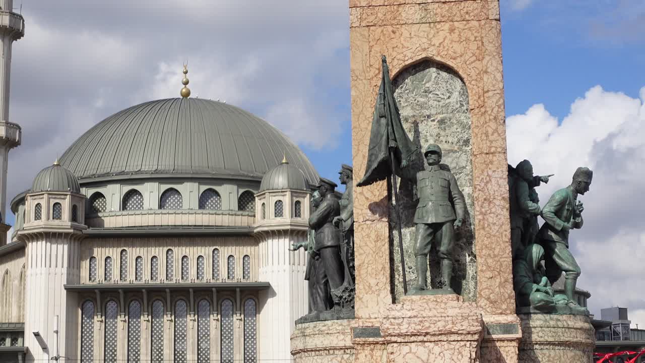 ankara, turquía: monumento con estatua de soldados y una mezquita en el fondo