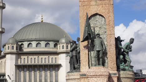 ankara, turkey: monument with statue of soldiers and a mosque in the background