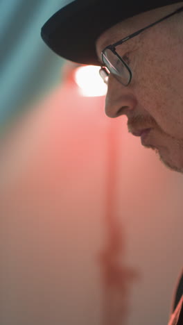 Closer side view of a keyboardist's hand playing a red sampler piano. The detailed shot highlights the musician's precise finger movements on the keys
