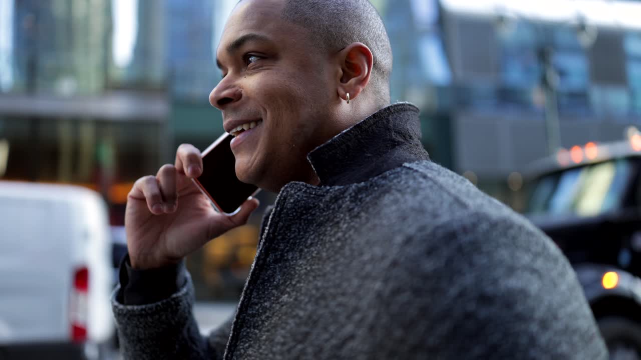 Man talking on phone in city street with yellow cab