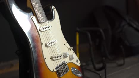 modern electric guitar on stand before concert, handheld view