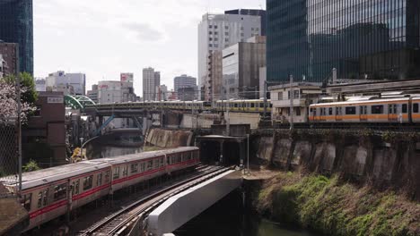 multiple tokyo train passing each other at ochanomizu station, early morning