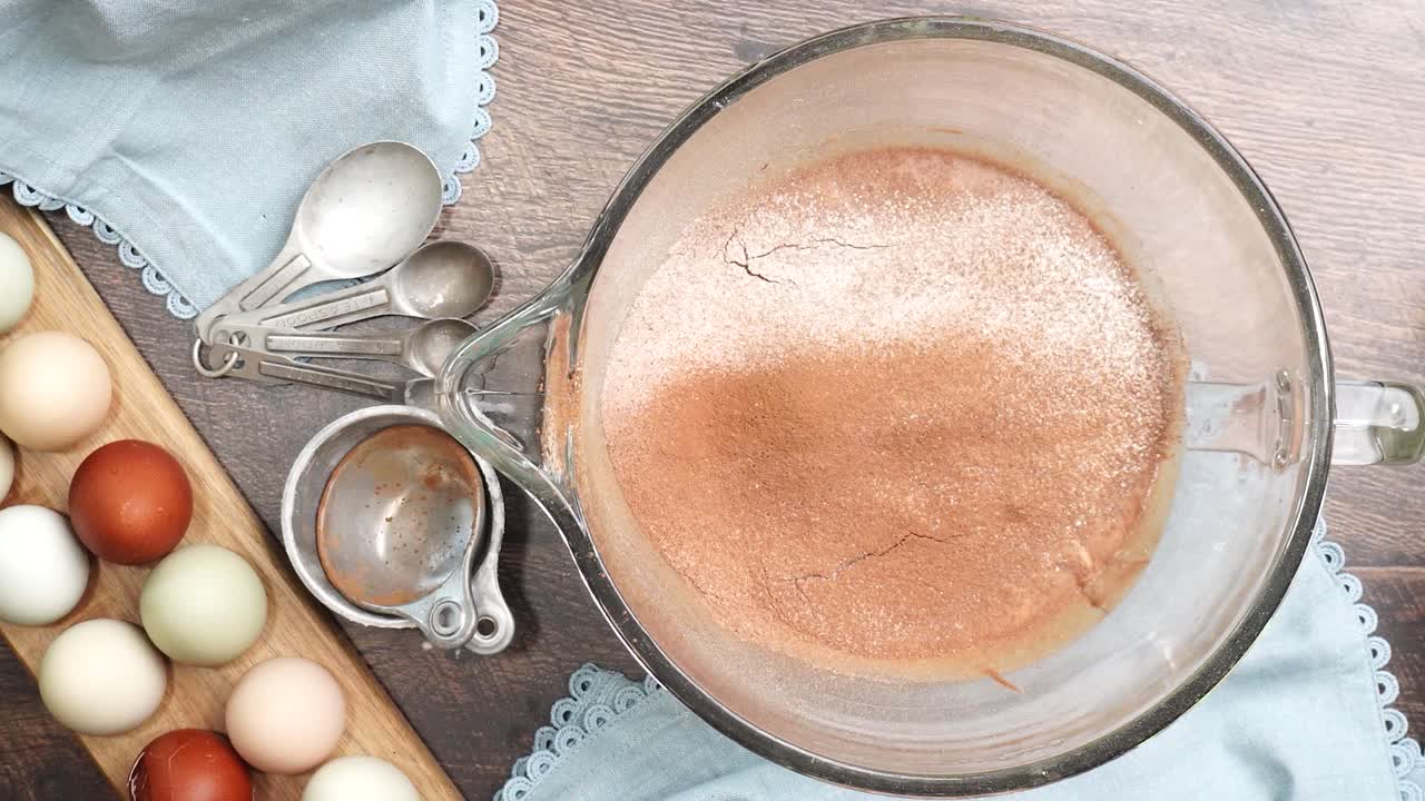 Baking delicious caramel pecan brownies. Mixing the brownie batter together with a spatula, folding it in.. Freshly baked gooey chocolate brownies with sweet caramel and nutty pecans.