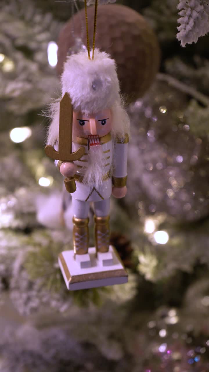 Vertical close-up footage of traditional wooden soldier figurine used as Christmas tree ornament, isolated with soft, blurred background