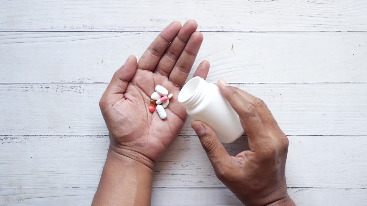 색 병에서 약을 복용하는 사람