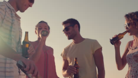 amigos felices bebiendo cervezas en la playa