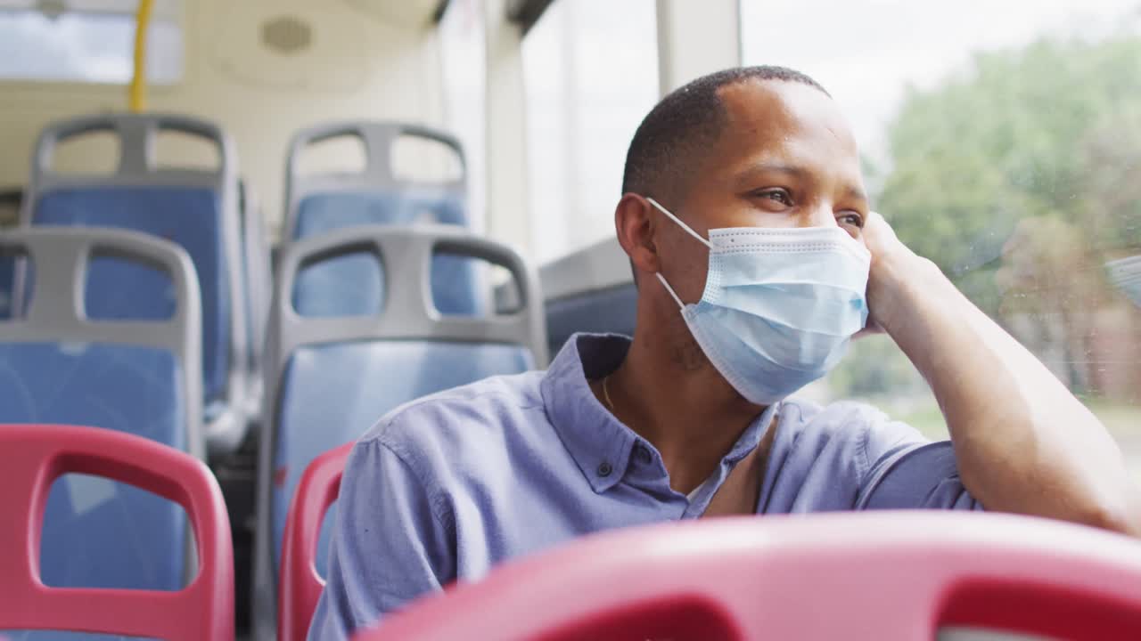 homem afro-americano com máscara de rosto sentado no ônibus