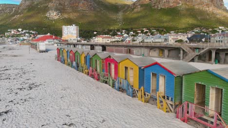 aerial fly over view of the famous colourful beach huts on muizenberg beach which is deserted during lockdown covid-19 pandemic, cape town, south africa