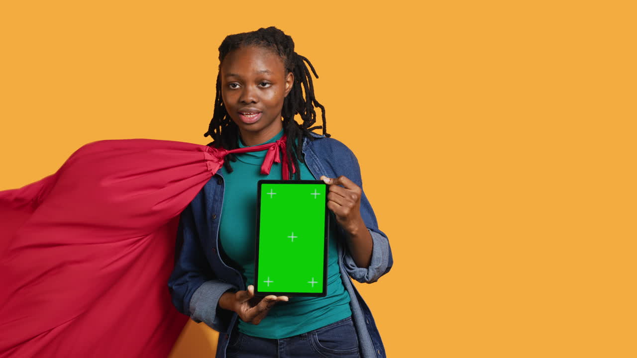 persona radiante haciendo cosplay de héroe recomendando una tableta de maqueta, fondo de estudio