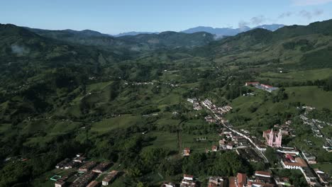 aerial view of jerico little town in colombia antioquia department in andes mountains, green valley with traditional village and old church cathedral drone fly above