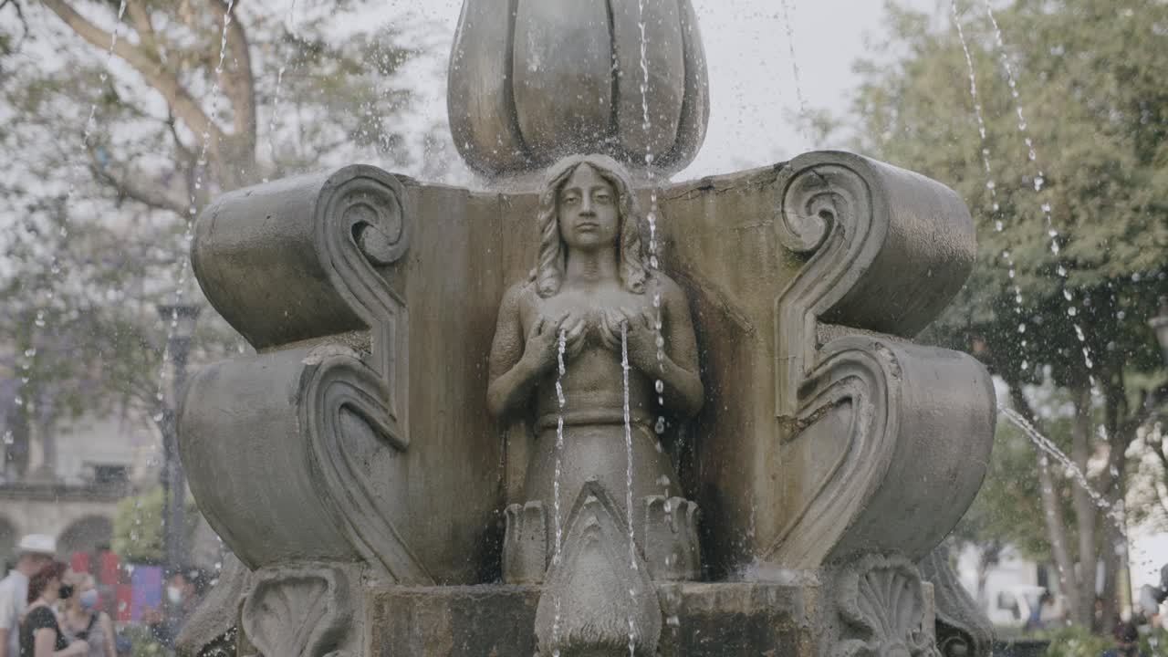 cuadrado en imágenes estáticas de una estatua de una mujer con agua saliendo de sus senos