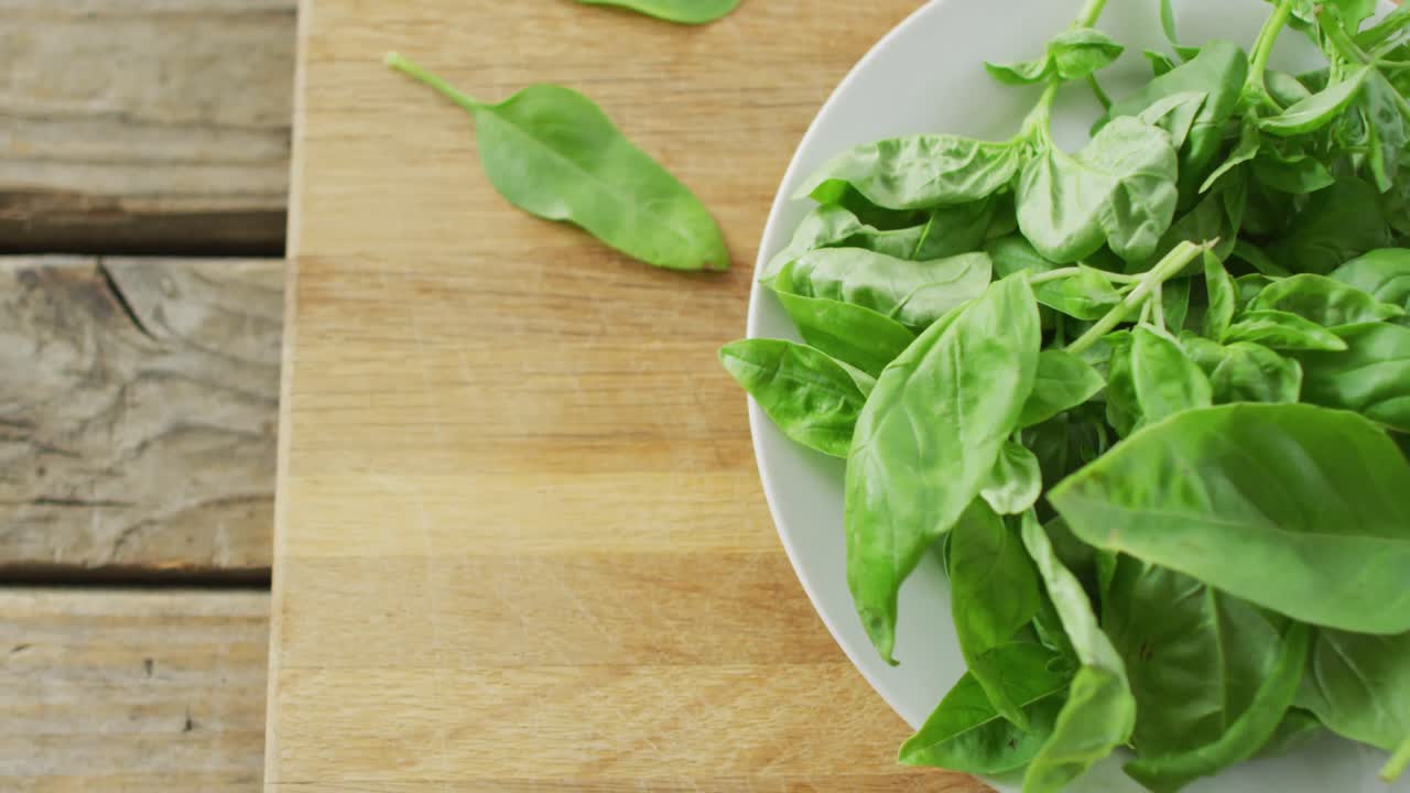 video de un primer plano de un plato de hojas de ensalada fresca sobre un fondo de madera