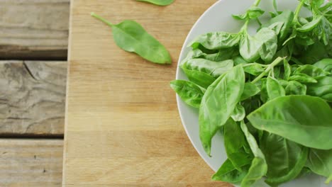 video of close up of bowl of fresh salad leaves on wooden background