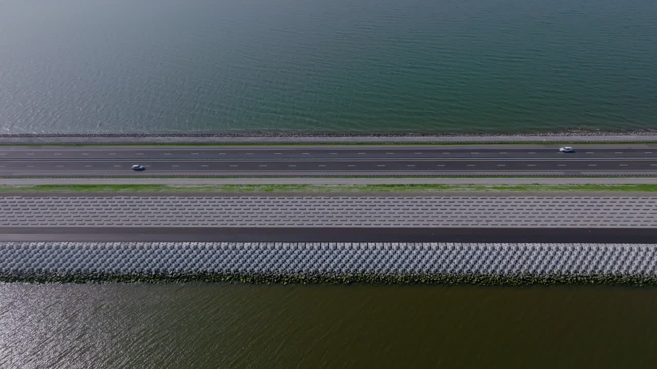 Aerial zoom out showing the Afsluitdijk dam with its straight highway extending across the water between provinces
