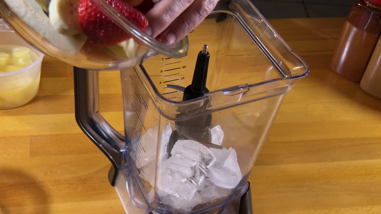 cámara lenta poniendo fruta en la licuadora para batido de frutas