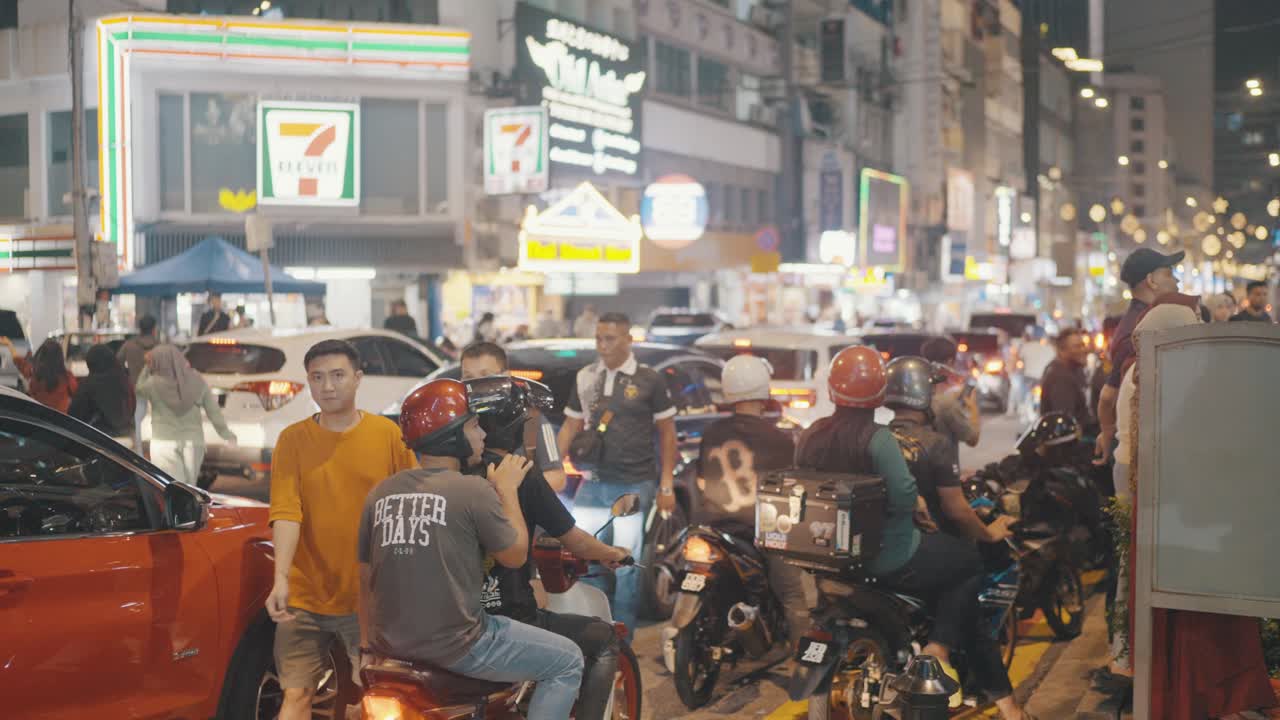 Slow motion shot of pedestrians passing by the traffic jam at streets of Kuala Lumpur, Malaysia.