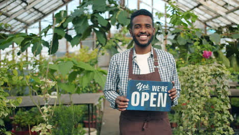friendly gardener welcoming customers in greenhouse