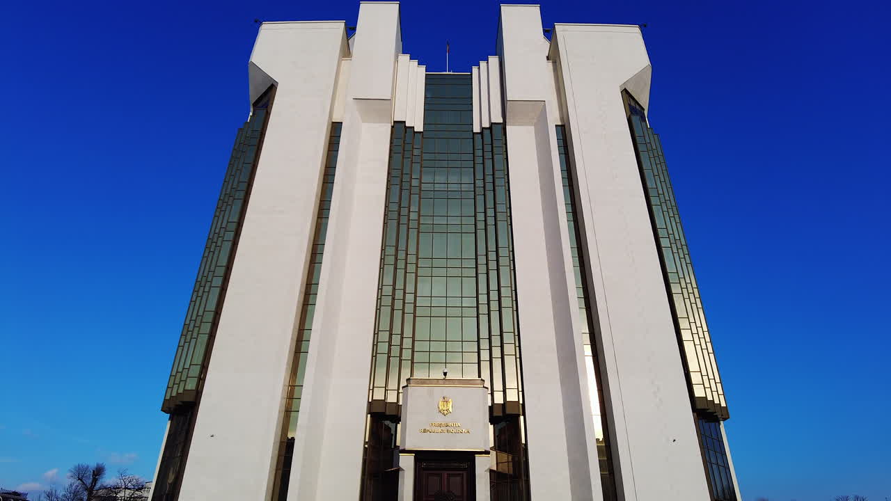 Chisinau, Moldova - December 23, 2021: Explore the stunning architecture of a modern government building set in a lively city under a bright blue sky. Discover the impressive design and vibrant atmosphere surrounding it