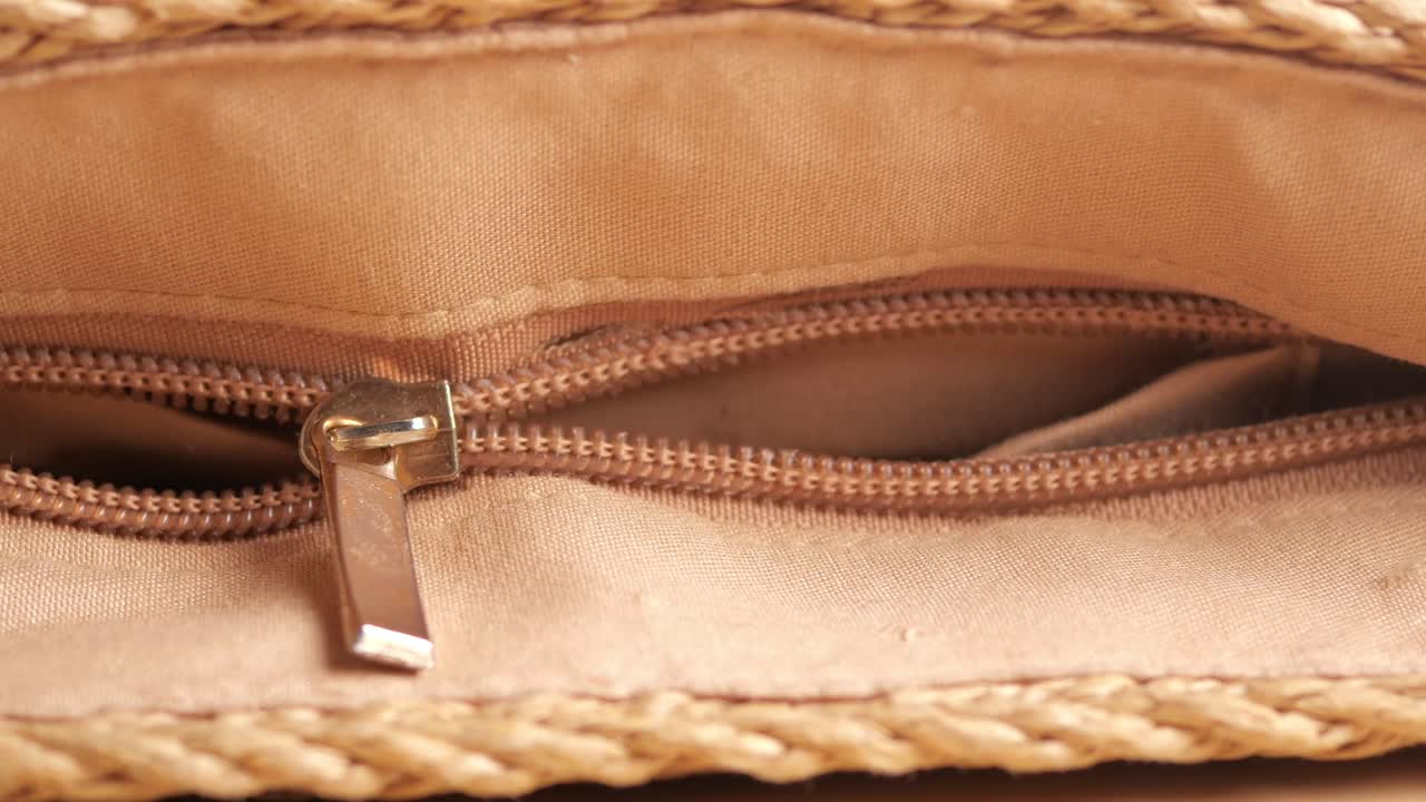Primo piano di una cerniera che si apre su una borsa in tessuto