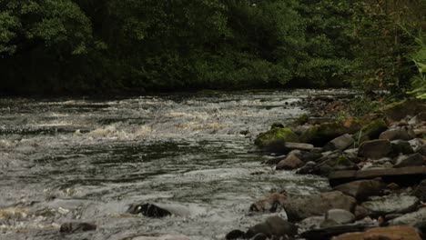 Toma-Panorámica-Lenta-De-Una-Sección-De-Flujo-Rápido-De-Un-Río-En-Escocia.