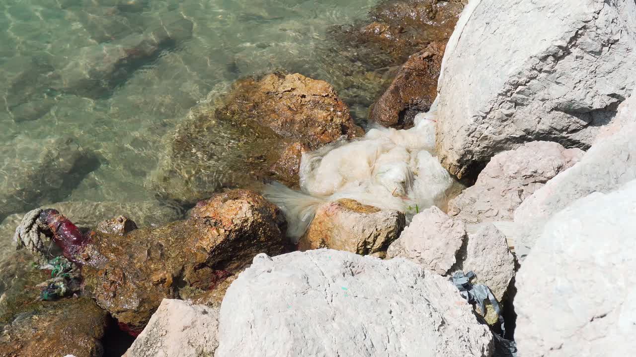 plástico y basura tirados en la costa rocosa del mar mediterráneo en mallorca