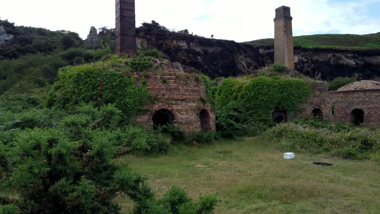 Cinematic aerial close-up shot of the remains of the Porth Wen Brickworks in Anglesey, North Wales, Europe