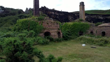 Cinematic-aerial-close-up-shot-of-the-remains-of-the-Porth-Wen-Brickworks-in-Anglesey,-North-Wales,-Europe