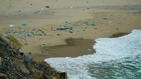paraíso playa de arena contaminada por basura arrojada por las olas del mar