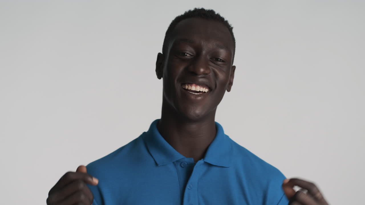 Uomo afroamericano felice su sfondo grigio