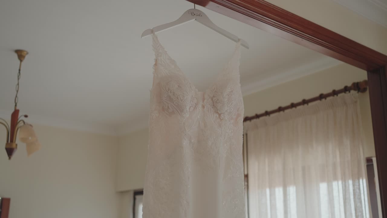 delicate bridal gown suspended in bright serene room setting