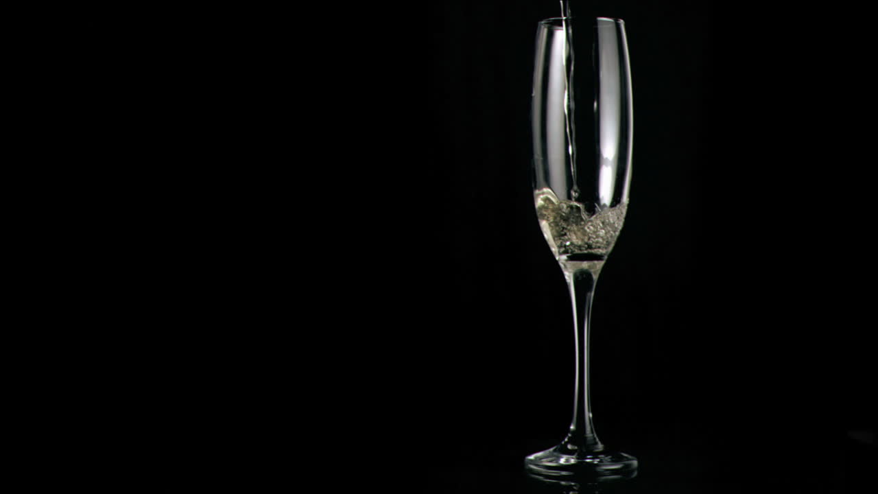 vino blanco vertido en súper cámara lenta en una flauta