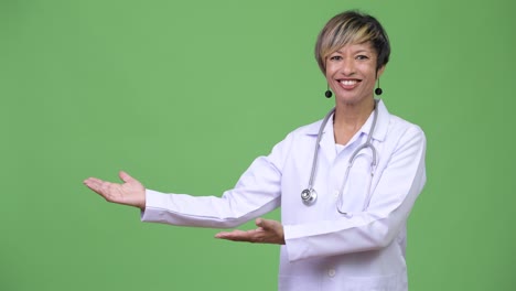 madura hermosa mujer multiétnica médico mostrando algo